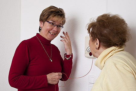 Eine Dame vom Empfang erklärt einer Bewohnerin alle technische und organisatorische Dinge im Haus