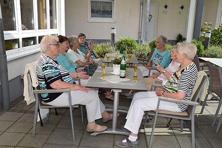 Ein Gruppe älterer Menschen sitzen gemeinsam am Kaffeetisch der Seniorenwohnanlage Haus am Park in Haan